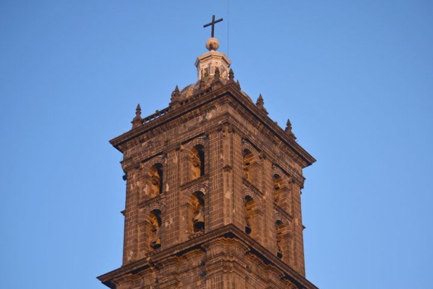 A tall, ornate church tower with a cross on top. 3