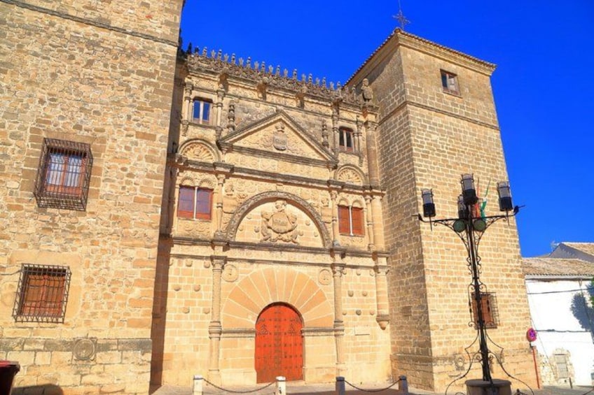 A historic stone building with a prominent arched entrance and a clock tower. 3