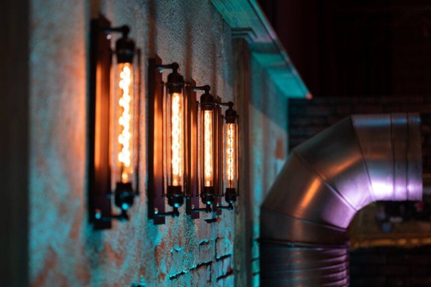 A row of vintage-style light fixtures mounted on a textured wall. 3