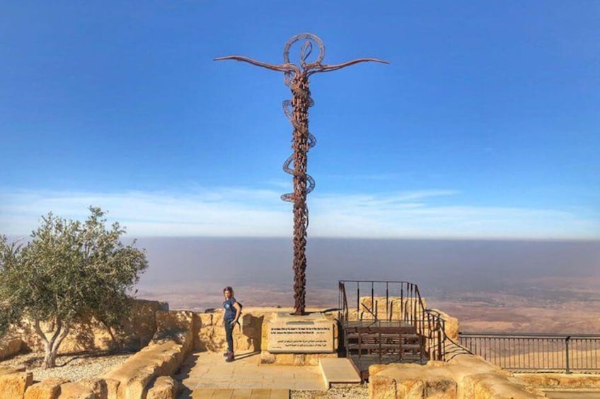 A metal sculpture with a spiral design, a staircase, and a clear view of the landscape. 4