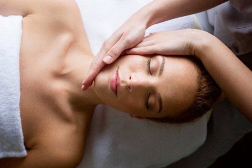 A person receiving a massage with hands on their head and neck. 2