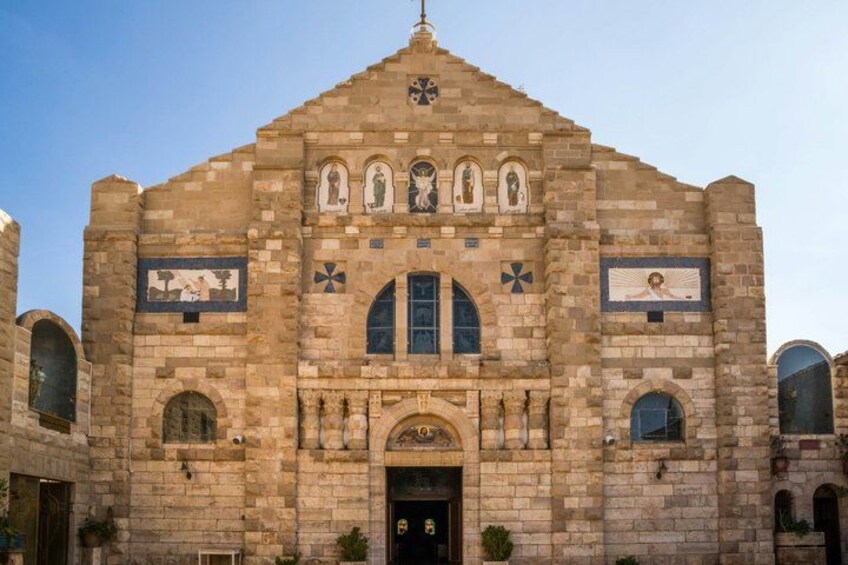 A historic stone building with arched windows and a central entrance. 2
