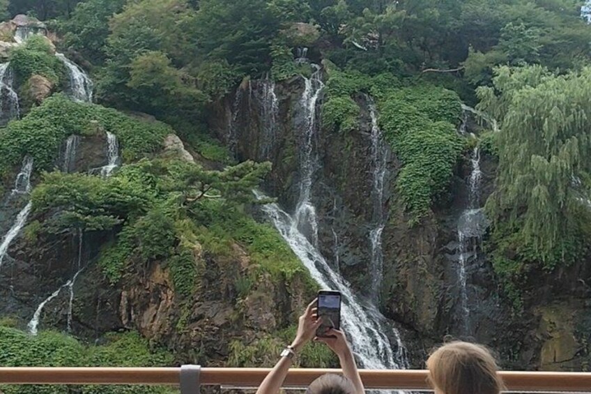 A person taking a photo of a waterfall. 2