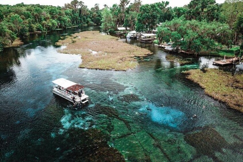 A river with clear water, a boat, and a dock. 1