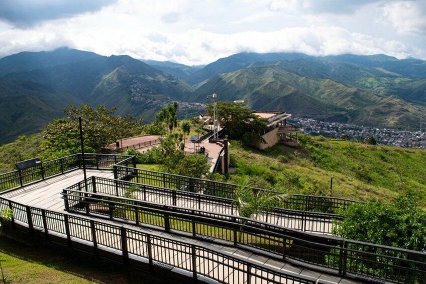 A mountainous landscape with a viewing platform and a small building. 5