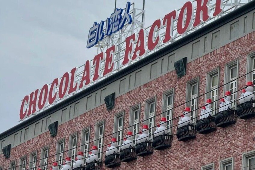 A building with a sign that reads 'CHOCOLATE FACTORY' and Chinese characters above it. 4