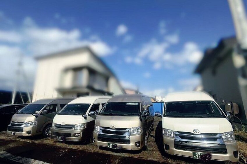A row of parked cars in a parking lot with a building in the background. 2