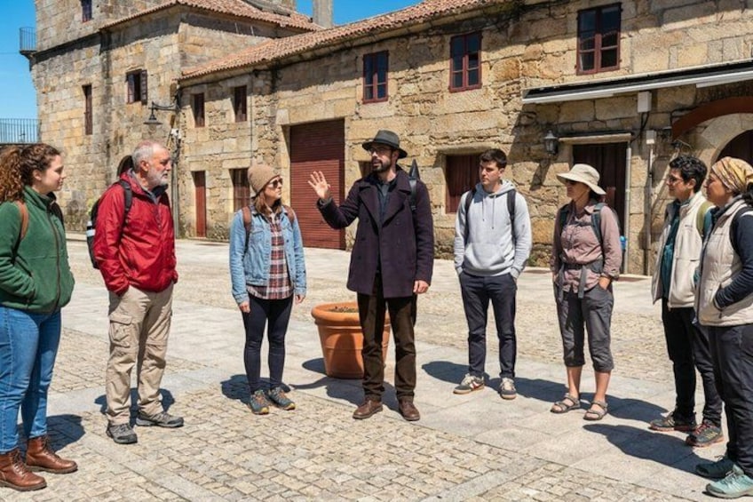 A group of people standing in a stone courtyard with a building in the background. 2