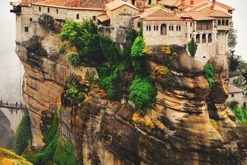 A historic building perched on a rocky cliff with lush greenery. 3