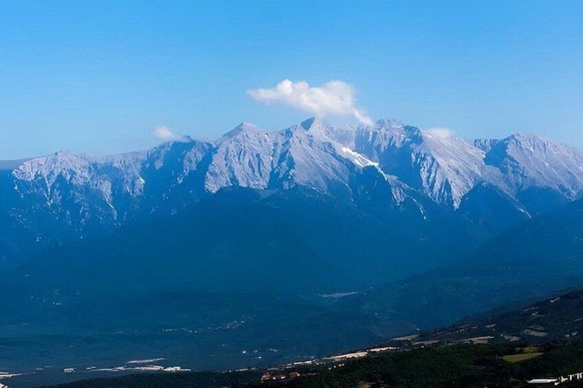 A mountain range with snow-capped peaks and a valley below. 1