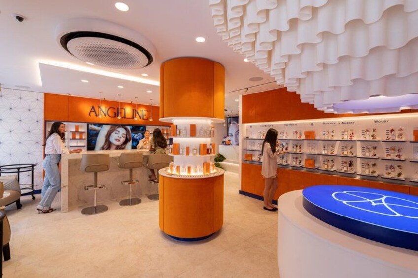 A modern retail store with a central orange display and a blue logo on a circular platform. 3