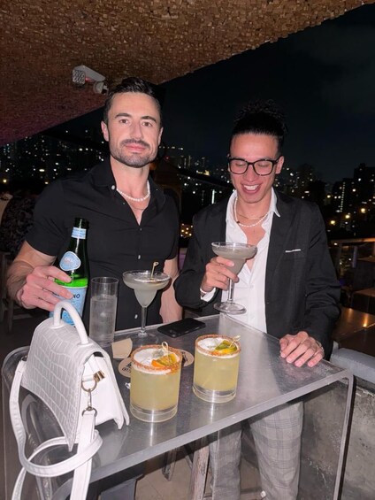 Deux personnes sont assises au bar, devant des boissons et une bouteille d’eau. 5