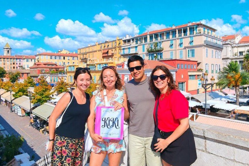 A group of people standing on a bridge with buildings in the background. 2