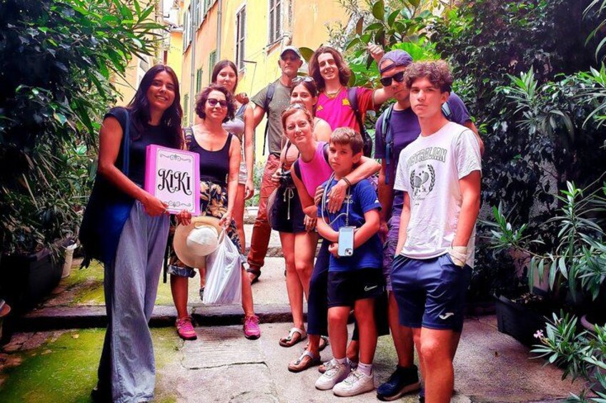 A group of people standing in a garden with plants and a stone pathway. 3