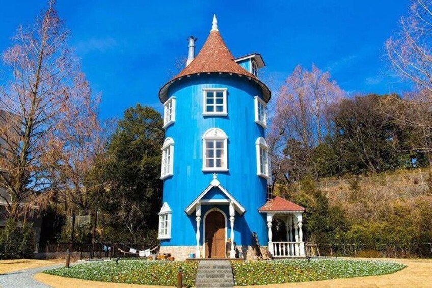 A blue building with a red roof, surrounded by trees and a garden. 2