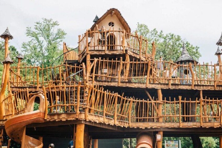 A wooden treehouse with multiple levels and a spiral staircase. 4