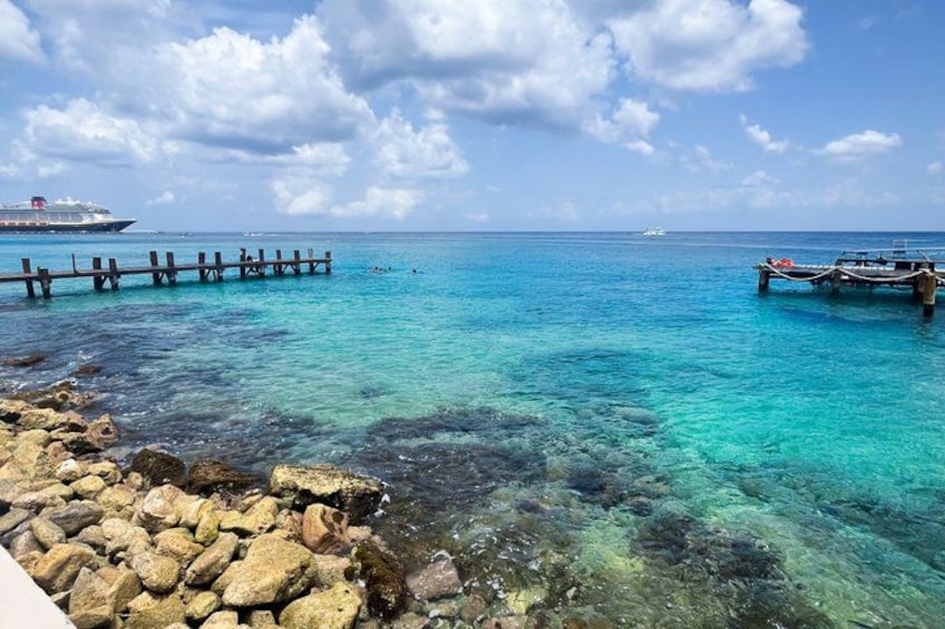 A clear blue sea, a wooden pier, and a boat. 5
