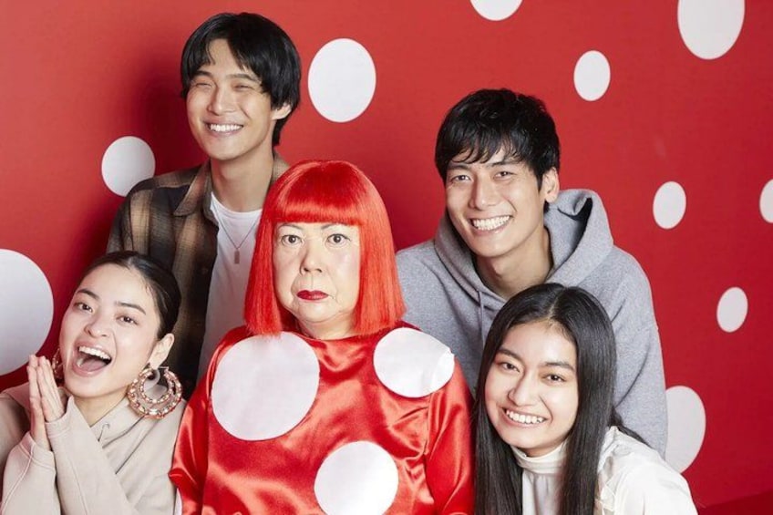 A group of people in front of a red background with white polka dots. 2