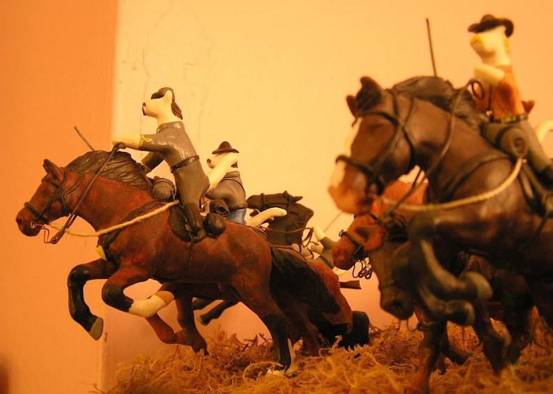 A model of a horse-drawn carriage with a figure riding it. 5