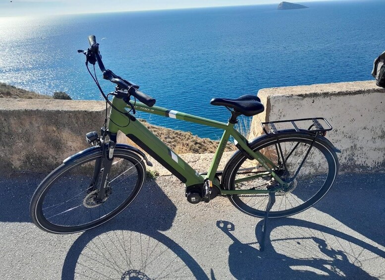 A green bicycle parked on a concrete ledge overlooking a body of water. 5