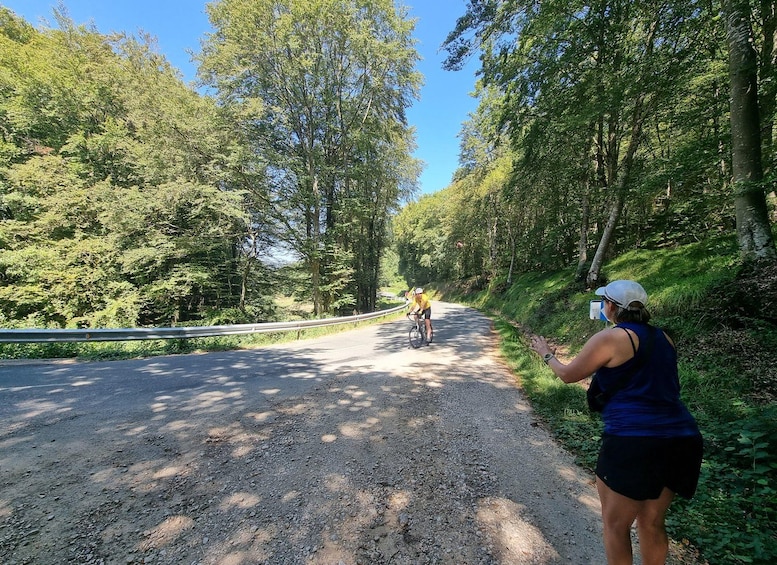 A gravel road with a cyclist in yellow and a person taking a photo. 3