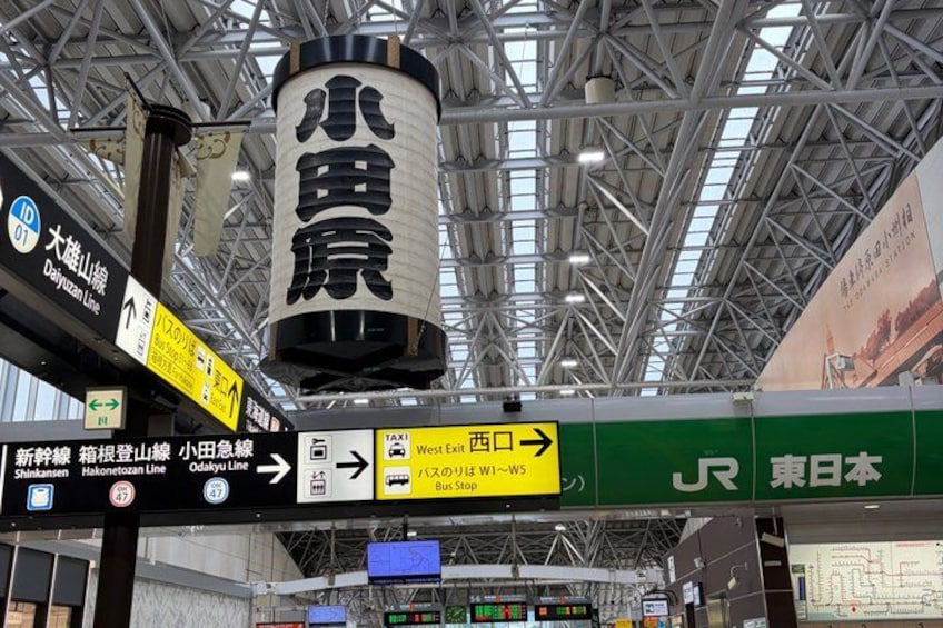 A train station with signage for exits, a bus store, and a JR East Japan sign. 2