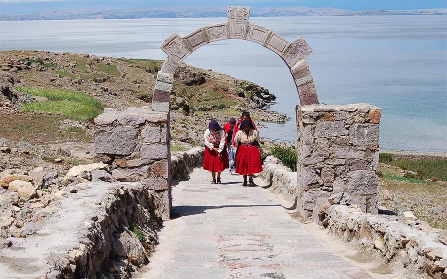 A stone pathway leading through an archway with a lake in the background. 5