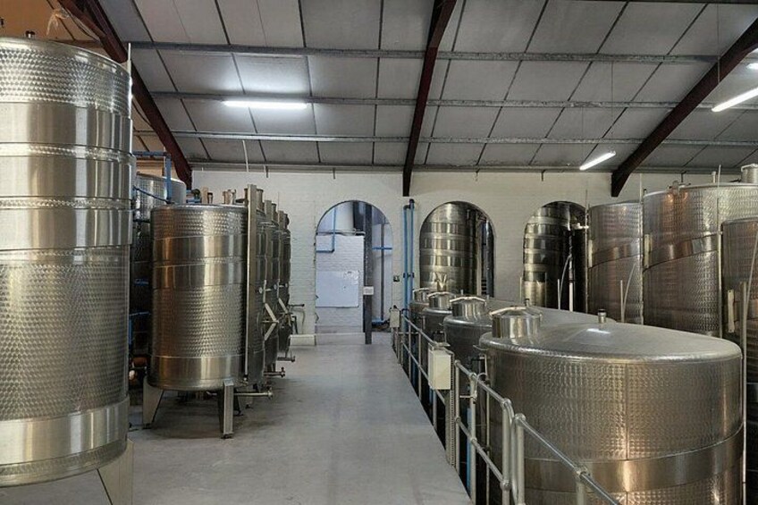 Stainless steel fermentation tanks in a warehouse. 4