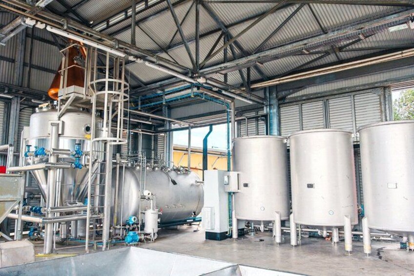 A large industrial facility with multiple stainless steel tanks, pipes, and a central processing unit. 3