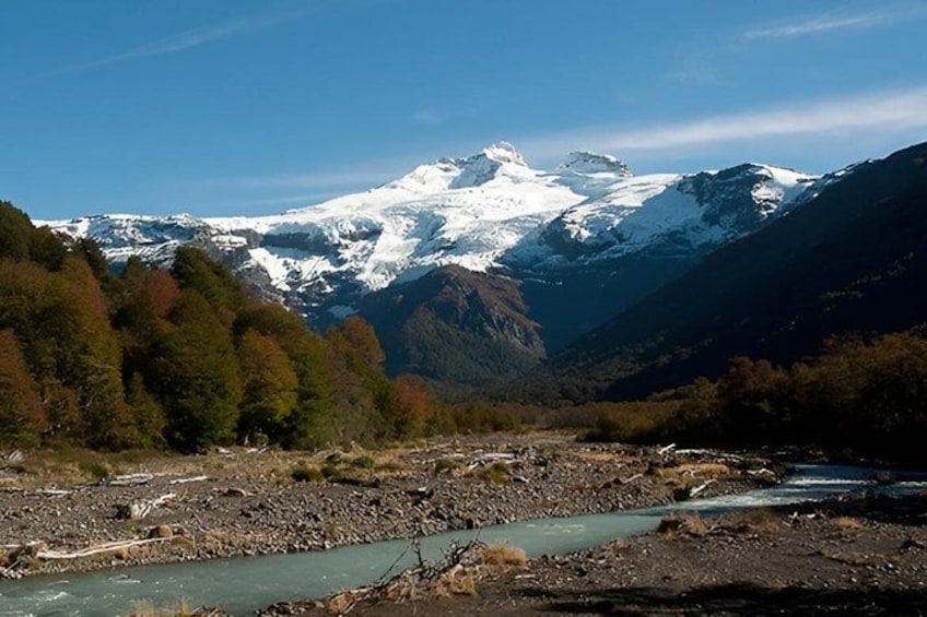 A river flowing through a valley with snow-capped mountains in the background. 1