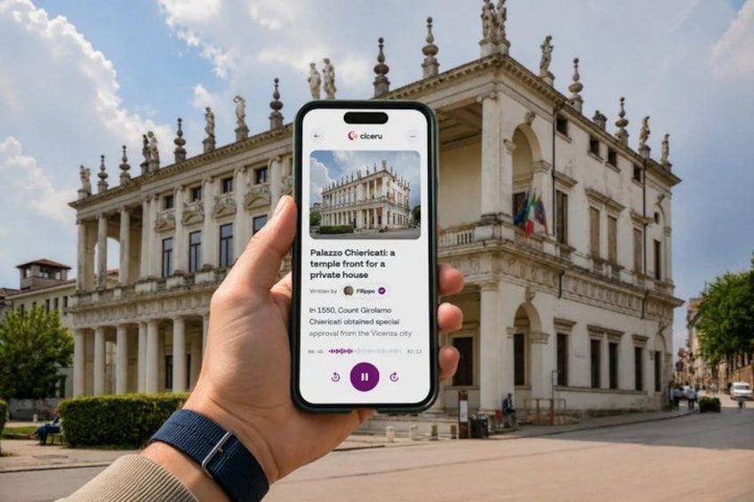 A hand holding a smartphone displaying information about a historical building. 1