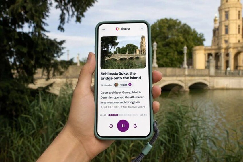 A hand holding a smartphone displaying a Google search result about Schlossbrücke, a bridge on an island. 1