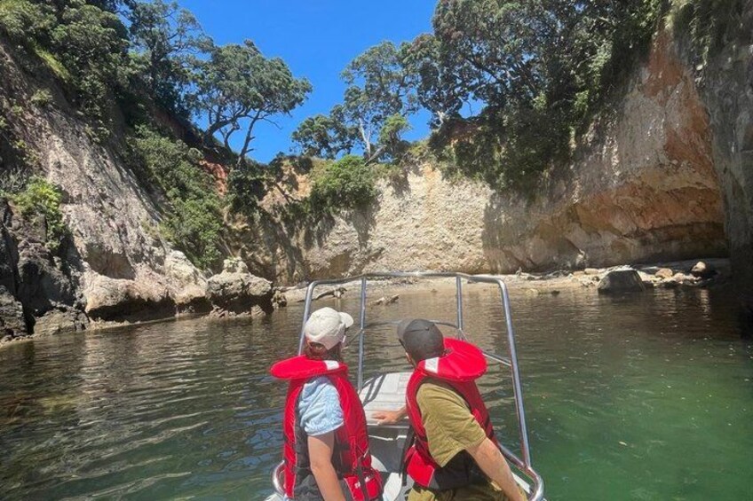 Two people in a boat on a river surrounded by cliffs. 1