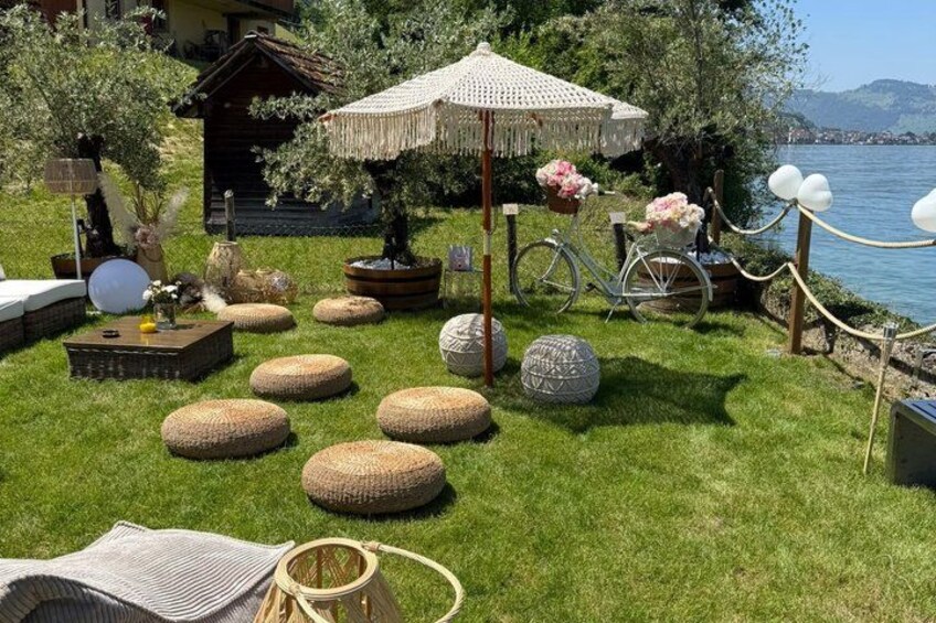 A garden with round seating, a bicycle, and a wooden structure by the water. 5