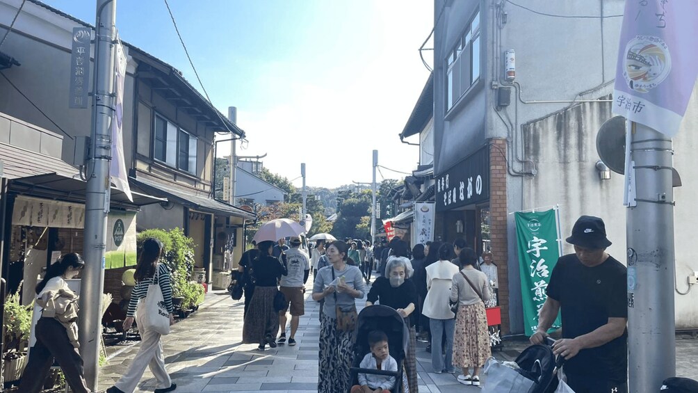 A busy street with pedestrians, shops, and traditional architecture. 2