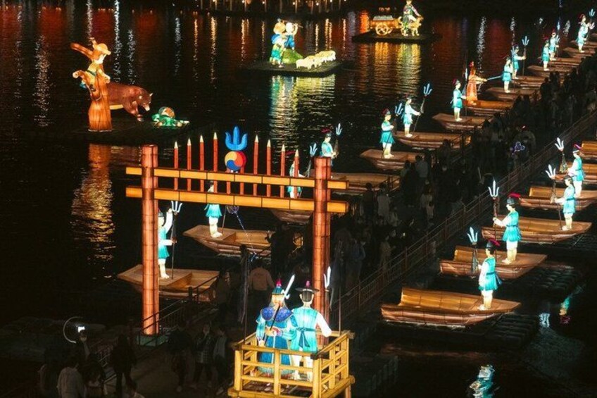A nighttime outdoor event with people in costumes on boats and a wooden structure. 4