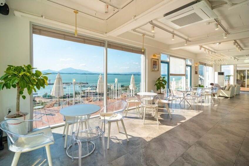 A spacious indoor area with large windows overlooking a body of water and mountains. 4