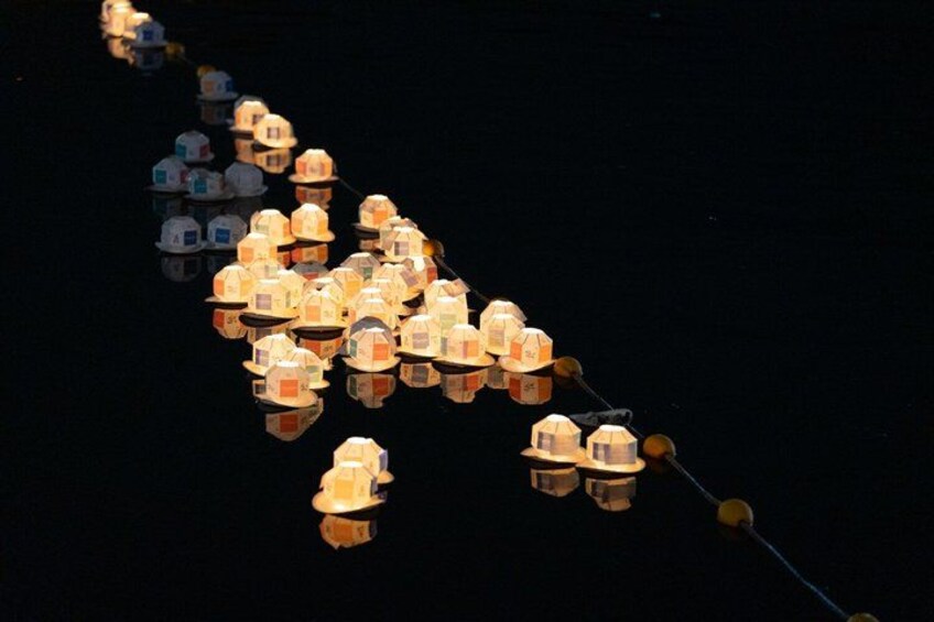 A series of illuminated structures reflecting on water. 3