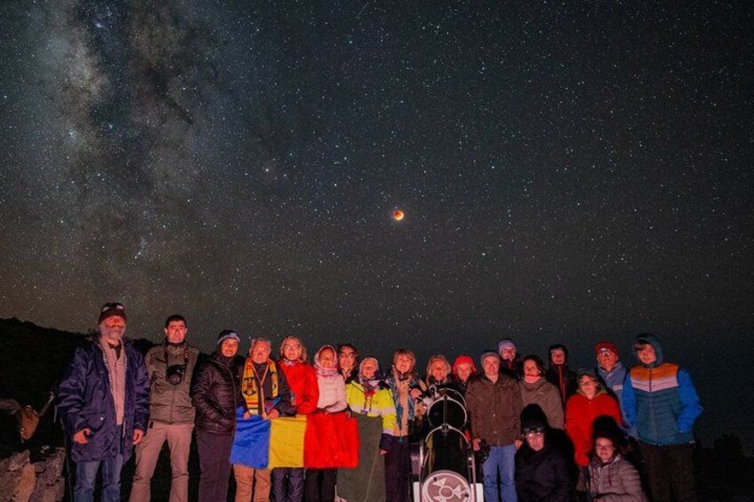 A group of people standing under a starry night sky with the Milky Way visible. 5