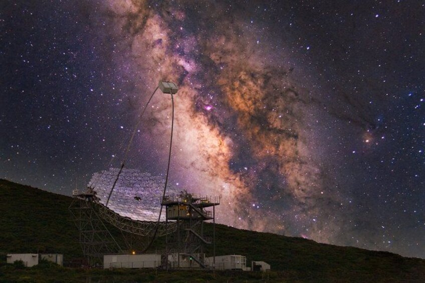 A night sky with stars and the Milky Way, a telescope, and a hill. 2