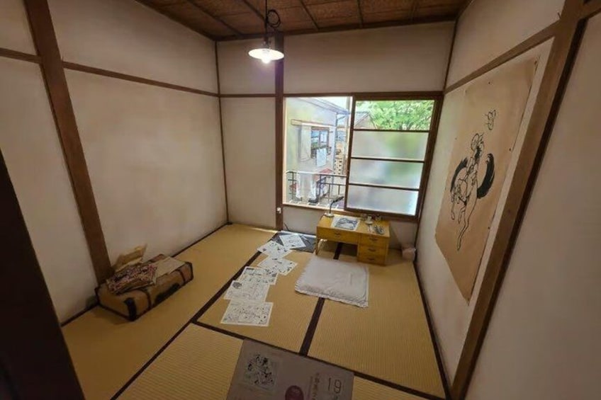 A tatami mat room with a shoji screen, a hanging light, and a traditional Japanese painting. 3