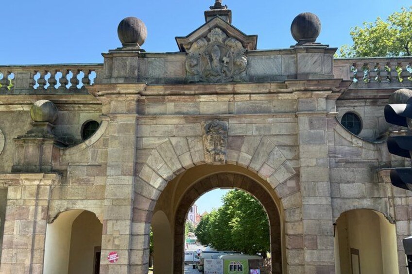 A stone archway with decorative elements and a sign. 5