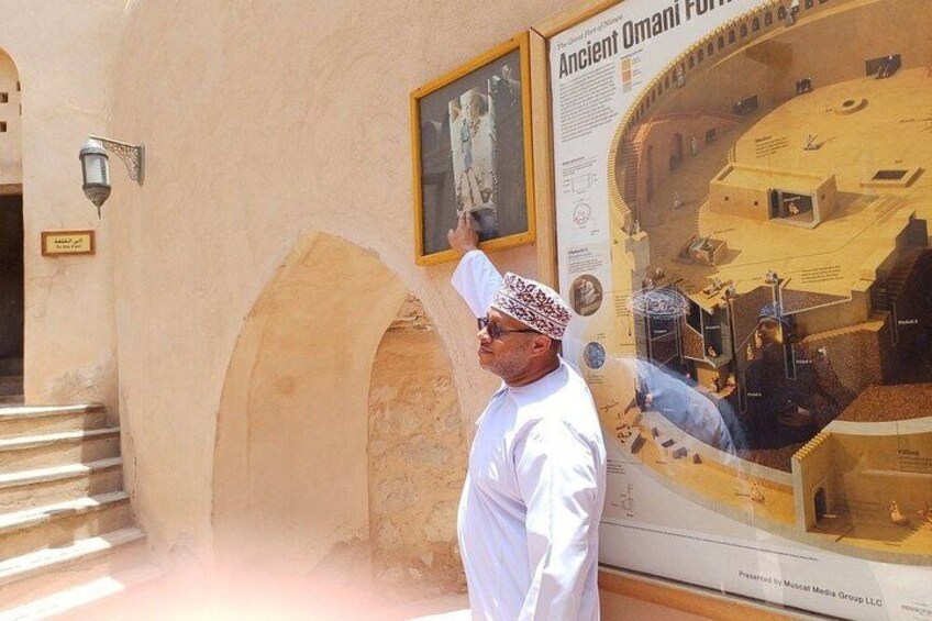 A man standing in front of a building with a large poster of an ancient structure. 2