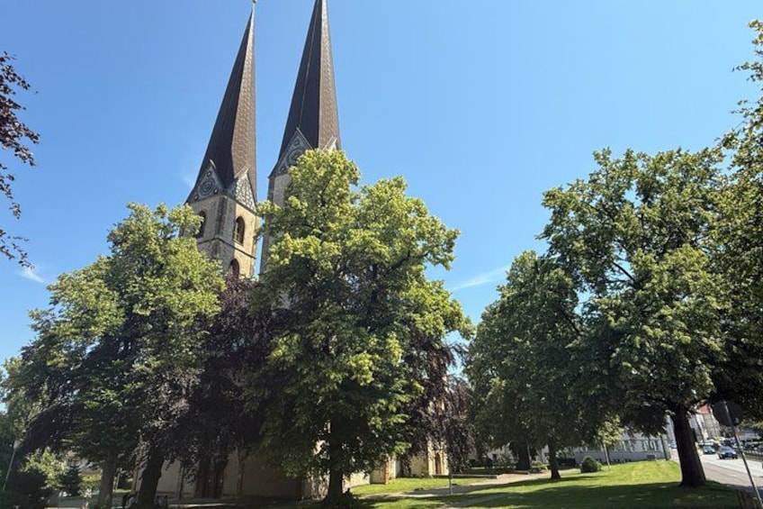 A church with two tall spires, surrounded by trees. 2