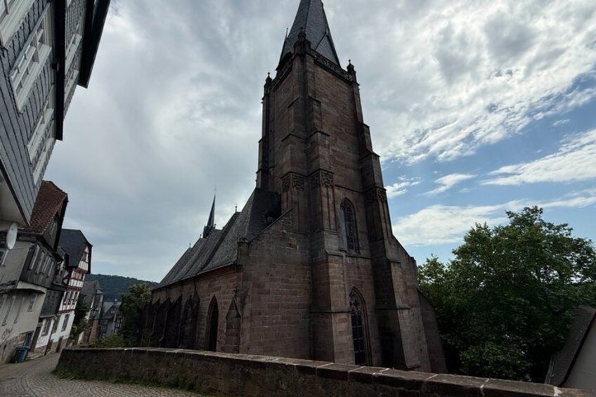 A historic church with a tall steeple, surrounded by traditional buildings. 2