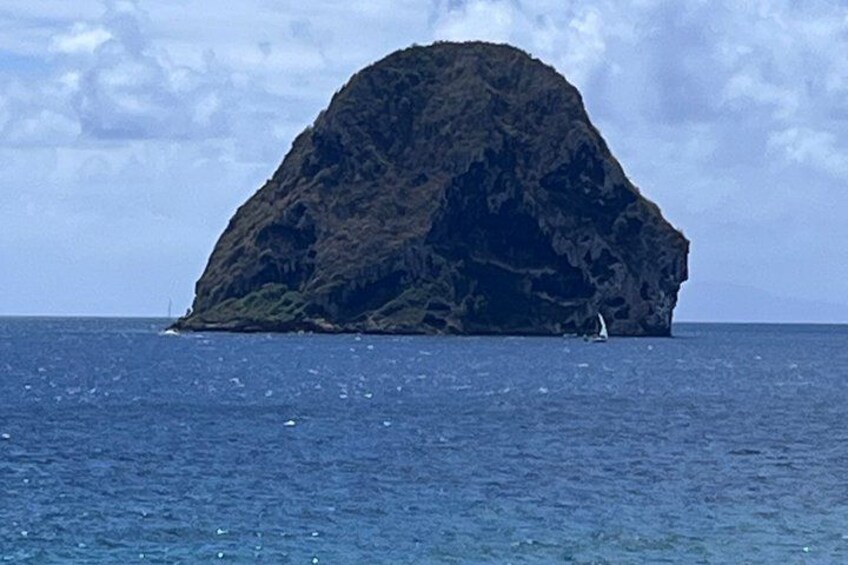 A large island with a sailboat in the water. 5