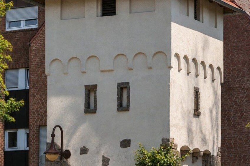 A building with a white facade, multiple windows, and a decorative arch pattern at the top. 4