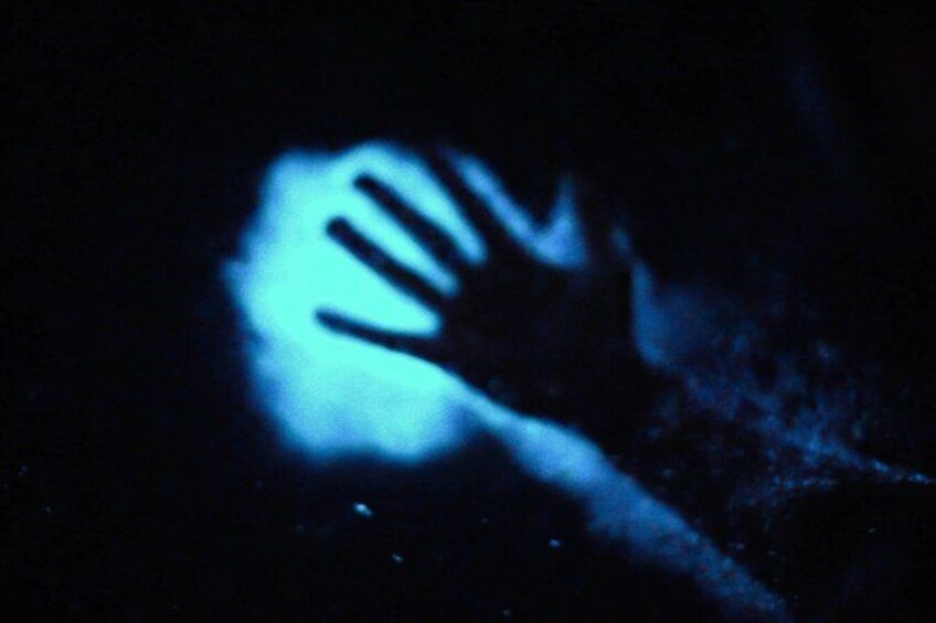 A hand silhouette against a dark background with a blue glow. 1