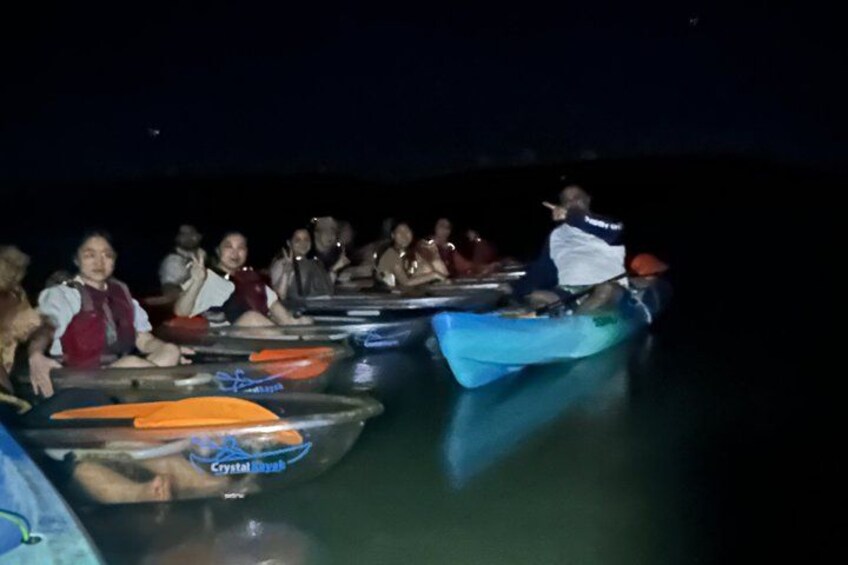 People in small boats on a body of water at night. 4