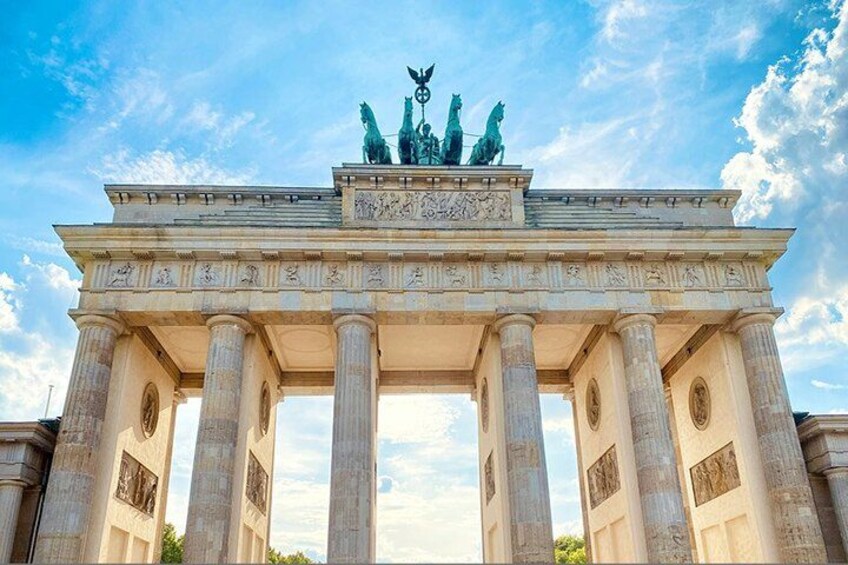 A large historical building with columns and a statue on top. 1